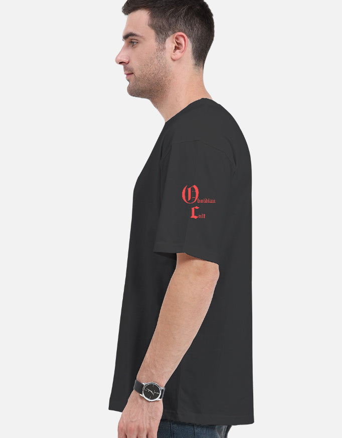 Side view of man wearing black t-shirt with red Gothic text on left sleeve against white background