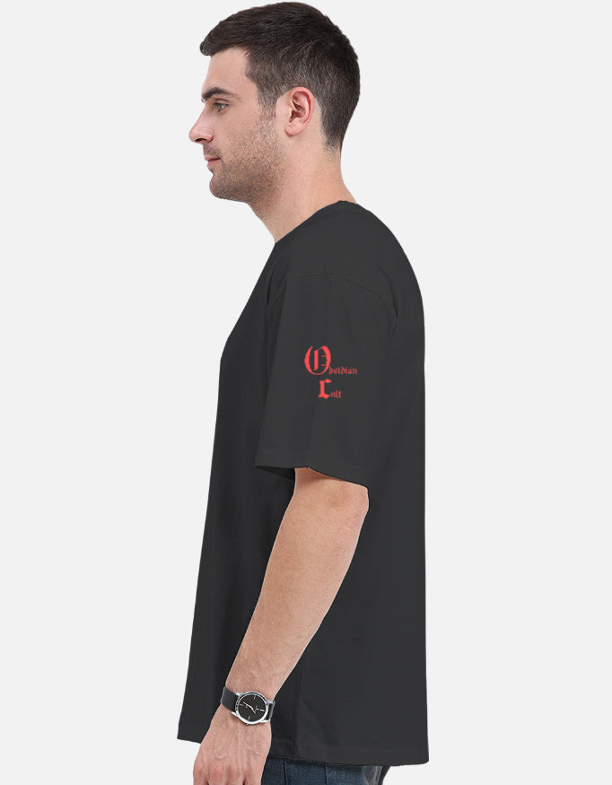 Side view of a man wearing a black Christian Cult graphic t-shirt with red text on left sleeve
