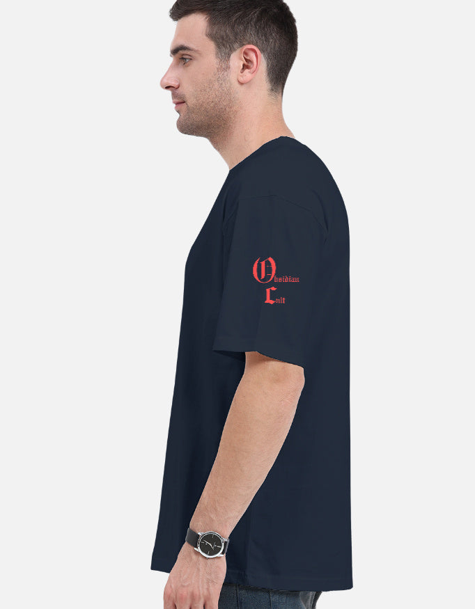 Side view of man wearing navy blue T-shirt with red Gothic text on left sleeve and black wristwatch