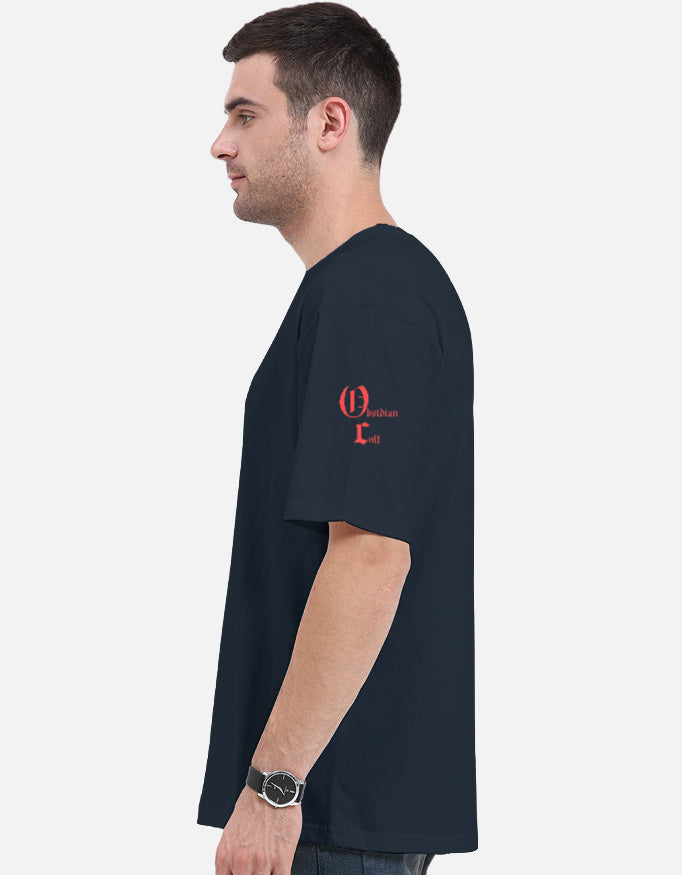 Side view of a man wearing a navy blue t-shirt with red text on left sleeve, plain background
